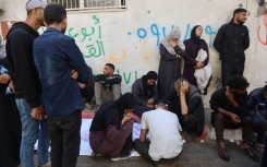 Palestinians mourn over the body of a relative who was killed in overnight Israeli strikes