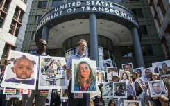People hold signs during a vigil in Washington DC for victims of the crash of Ethiopian Airlines Flight ET302