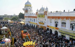 As the procession spilled into the streets, Muslims came out onto rooftops, showering Sikh pilgrims with rose petals