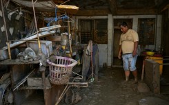 A resident of Cebu province's Liloan town examined belongings covered in mud following the devastation of Typhoon Kalmaegi
