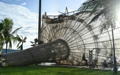 People rest near a structure, damaged by typhoon Kalmaegi, in the Quy Nhon area of Gia Lai province, central Vietnam