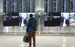 A man looks at the departures board at Newark Liberty International Airport
