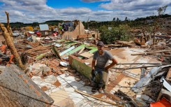 Nereu Sabadini sits on the debris of his house that was destroyed by a tornado in Rio Bonito do Iguaçu, Brazil