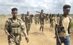 Soldiers of the Somali National Army (SNA) walk near the front line