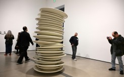 Visitors look at "No title (stacked plates, white)," a 1993 large-scale art work by Robert Therrien, during the exhibition "Robert Therrien: This is a Story" at The Broad in Los Angeles, California