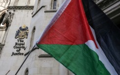 A Palestinian flag held up by protesters outside the London appeal court where the Palestine Action case is being heard