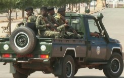 Men in military uniforms patrol the main road leading to Guinea-Bissau's presidential palace after heavy gunfire was heard