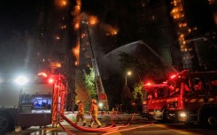 Firefighters spray water on flames as a major fire engulfs several apartment blocks at the Wang Fuk Court residential estate in Hong Kong's Tai Po district