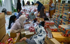 People prepare food aid packages for flood-affected residents in Thailand's southern province of Narathiwat