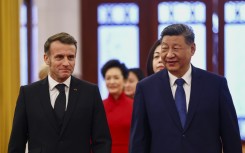 China's President Xi Jinping (R) and France's President Emmanuel Macron attend a welcome ceremony at the Great Hall of the People in Beijing