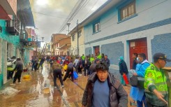 Police and residents try to extinguish a fire in a restaurant in the Peruvian town of Huancane that killed 10 students