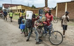 Lines of civilians crossed the border, watched by Rwandan police