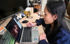 Estella, 14, a homeschooled student, does a Spanish class from her bedroom in Shanghai