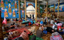 Residents rest inside a temple after they evacuated following clashes along the Cambodia-Thailand border, in Siem Reap province