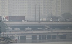 Vehicles drive on a highway during heavy air pollution in Hanoi on December 11, 2025
