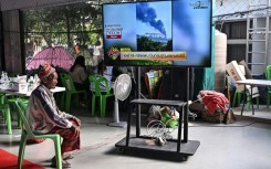A displaced resident watches the news at an evacuation center in the Thai border province of Surin on December 11, 2025