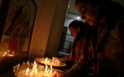 Hanaa Masoud lights candles for her husband Boutros Bashara, who was among those killed in the attack in June