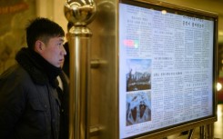 A man reads North Korea's Rodong Sinmun newspaper on a digital monitor at a metro station in Pyongyang