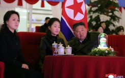 This picture taken on December 31, 2025 and released by North Korea's official Korean Central News Agency (KCNA) via KNS on January 1, 2026 shows North Korean leader Kim Jong Un, his daughter Kim Ju Ae (C) and wife Ri Sol Ju (L) watching a New Year's celebration performance at the May Day Stadium in Pyongyang