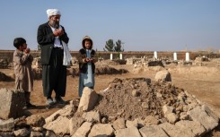 Gul Ahmad (centre) along with his deceased stepbrother Habibullah's son Waheed (right) and Saeed offering prayers over his grave in Ghunjan