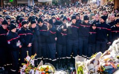 Firefighters from the Municipality of Crans-Montana gathered around a makeshift memorial to pay their respects