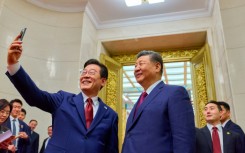 South Korea's President Lee Jae Myung (L) takes a selfie with China's President Xi Jinping (R) after a dinner at the Great Hall of the People in Beijing on January 5, 2026