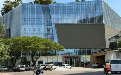 Motorists ride past the Prince Group Headquarters in Phnom Penh