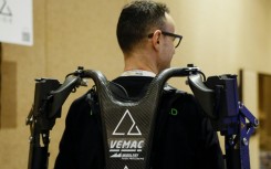 An exhibitor displays AGADE's Agadexo Lowback, its next-generation AI-driven industrial exoskeleton