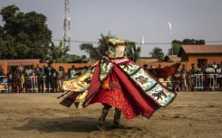 A costumed Egungun figure, revering ancestors, dances during festivities last January in Ouidah