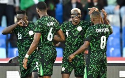 Victor Osimhen, wearing his trademark mask, celebrates after scoring Nigeria's opening goal against Algeria
