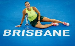 Aryna Sabalenka celebrates with the trophy after winning the women's singles final against Marta Kostyuk at the Brisbane International