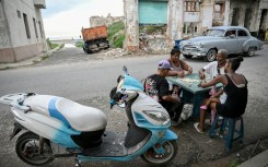 Cubans play dominoes on a street in Havana