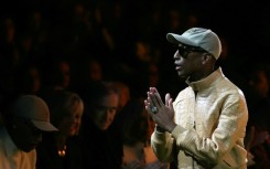 US rapper and fashion designer Pharrell Williams greets the audience at the end of the Louis Vuitton show