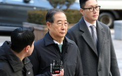 Former South Korean prime minister Han Duck-soo (C) arrives at the Seoul Central District Court for his first sentencing trial in the insurrection case in Seoul on January 21, 2026