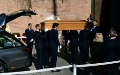 Pallbearers carry the coffin of the late Italian fashion designer Valentino Gavarani to enter the Basilic of Santa Maria degli Angeli e dei Martiri for a funeral ceremony, in Rome on January 23, 2026.