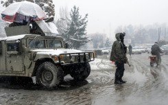 A Taliban security personnel stands guard at a checkpoint during snowfall in Kabul on January 22, 2026.