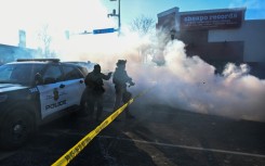 Tear gas is deployed by law enforcement in Minneapolis as demonstrators gather near the site where officials say a man was shot by federal agents