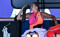 Aryna Sabalenka holds an air conditioning pipe to cool down during her women's singles quarter-final