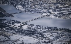 This aerial view shows a snow-covered Washington, DC, including the Lincoln Monument, the Kennedy Center, the Potomac River and the National Mall from Air Force One