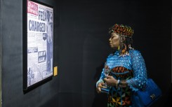 Yeni Kuti, Fela's daughter, looks at a headline on Fela Kuti at the Afrobeat Rebellion exhibition in 2025