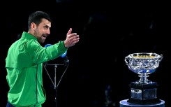 Novak Djokovic looks at the Australian Open's Norman Brookes Challenge Cup after losing in the final to Carlos Alcaraz