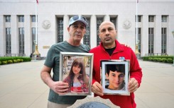 Parents Mariano Janin and George Nicolaou hold photos of their children outside the Los Angeles County Superior Court in Los Angeles
