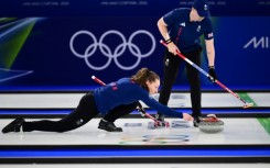 Britain's Jen Dodds aims her stone as her partner Bruce Mouat looks on during their victory in the curling mixed doubles, the opening event of the Winter Olympics