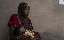 Khausara Saleem, 28, holds her three-month-old baby after fleeing the massacre in the Nigerian village of Woro