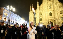 Italian ballet dancer Nicoletta Manni carries the Olympic flame in front of Milan's gothic Duomo ahead of Friday's opening ceremony