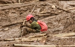 A rescuer rests as they search for victims buried by a landslide in Pasirlangu village