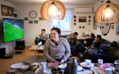 A giant flat screen in Olsen's house shows a football match from England's Premier League