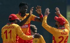 Zimbabwe's Blessing Muzarabani (2L) celebrates with teammates after taking the wicket of Oman's captain Jatinder Singh