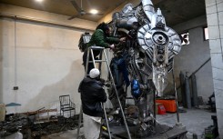 Sculptor Ehtisham Jadoon spray paints a model of Optimus Prime, a film character from Transformers, made from scrap metal at his studio