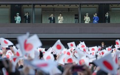 Japan's Emperor Naruhito (centre L), Empress Masako (centre R), and other members of the Imperial Family wave to well-wishers during a public audience celebrating the Emperor's 66th birthday, at the Imperial Palace in Tokyo